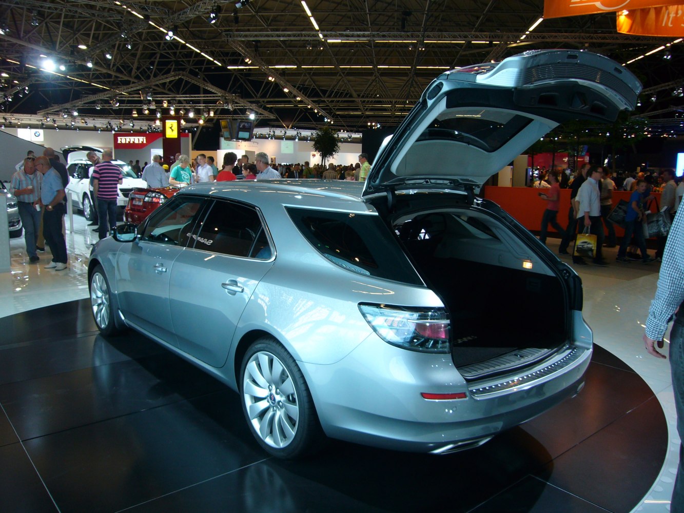 Silver station wagon with open rear hatch in exhibition hall
