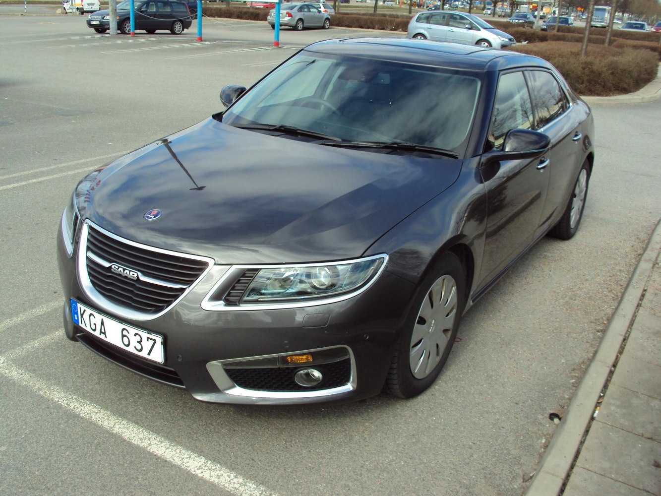 Front grille and headlights of a sedan in a parking lot
