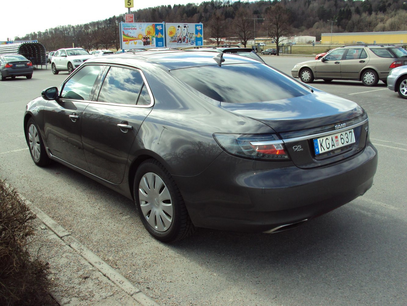 Rear-side view of grey sedan with tinted windows and shark fin antenna