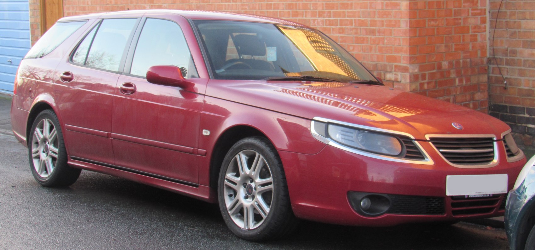 Red station wagon front side view with alloy wheels and distinct headlights