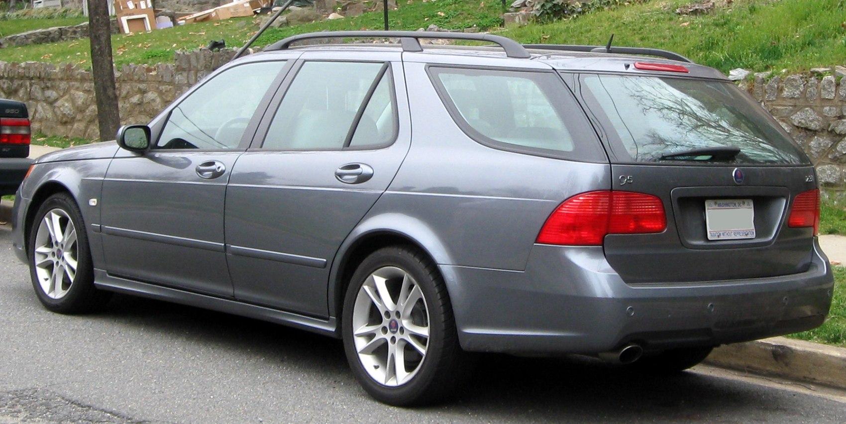 Rear side view of silver station wagon with alloy wheels and roof rails