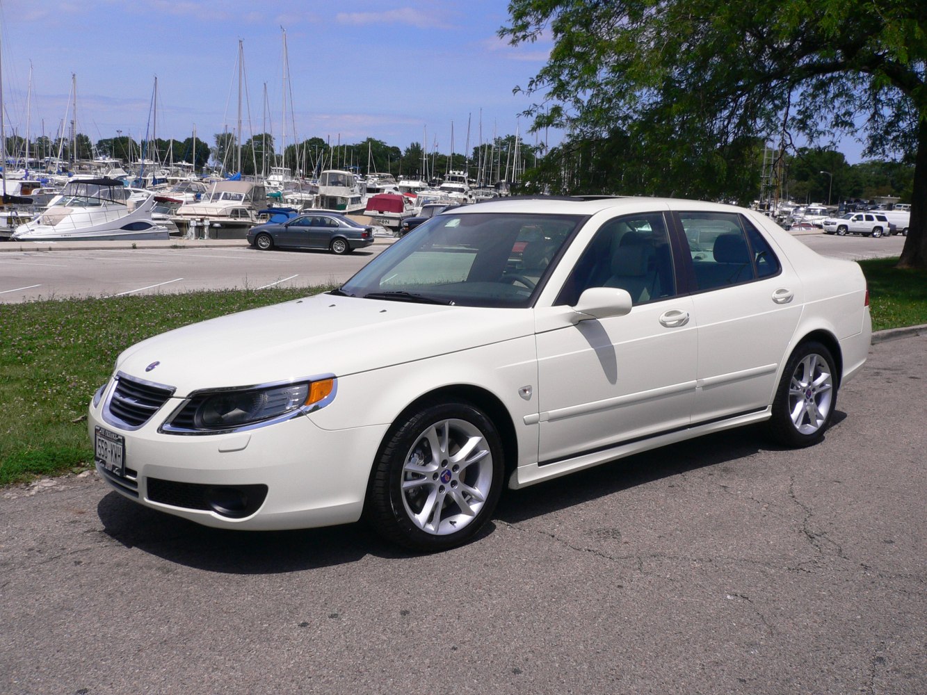 White sedan with alloy wheels and sunroof in daylight