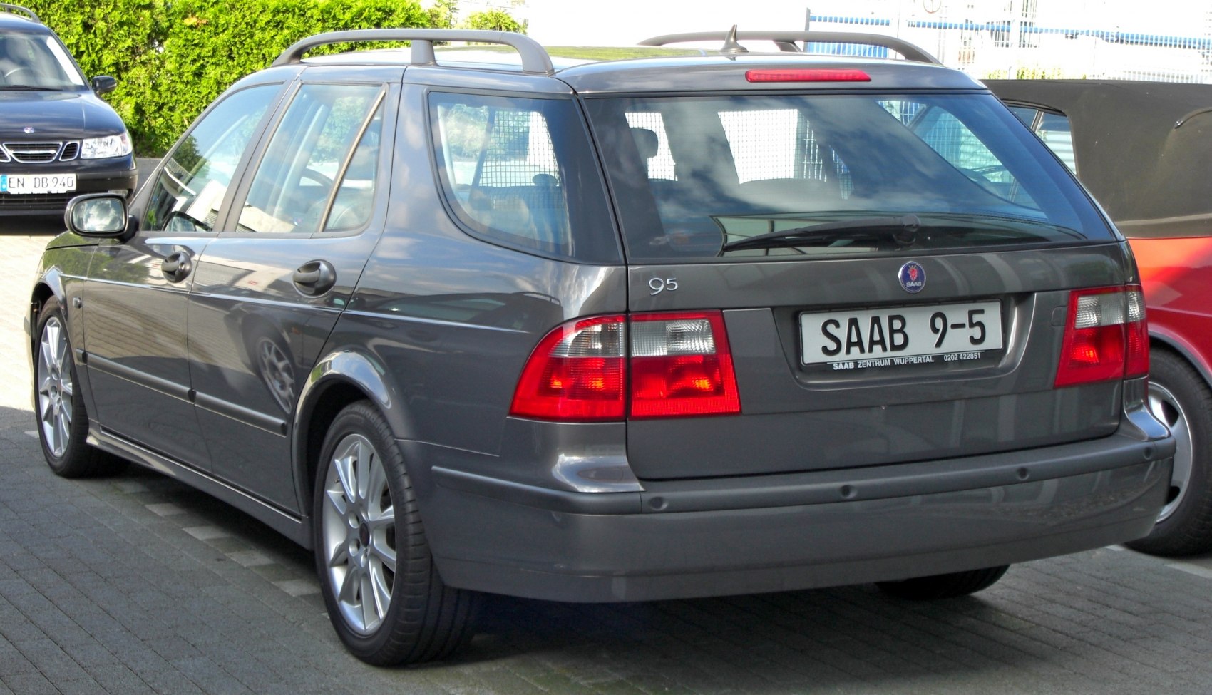Rear three-quarter view of a gray estate car with roof rails and distinctive tail lights.