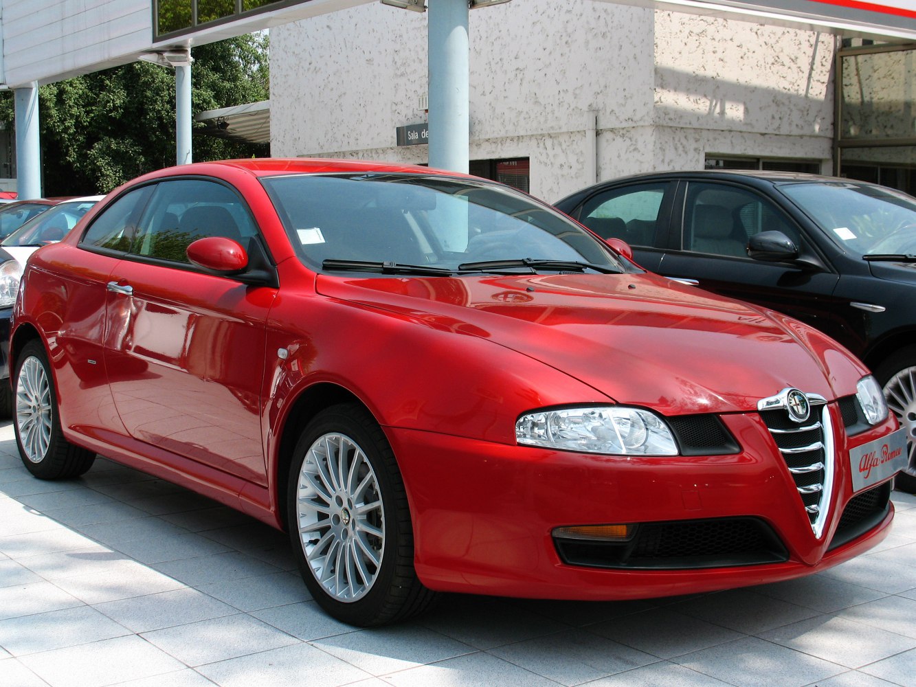 Red compact coupe with Alfa Romeo's signature V-shaped grille and sporty alloy wheels