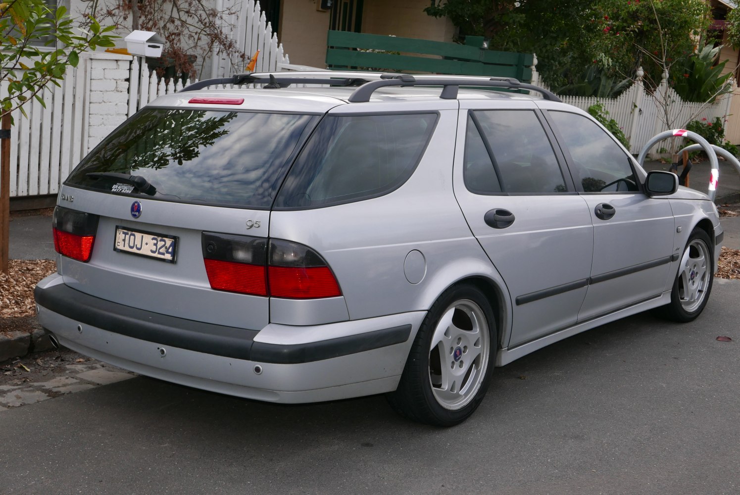Rear and side view of silver station wagon with roof rails and alloy wheels.
