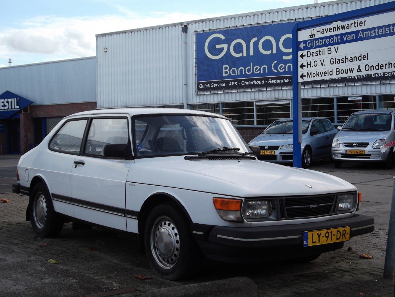 Two-door hatchback with square headlights and steel wheels in white.