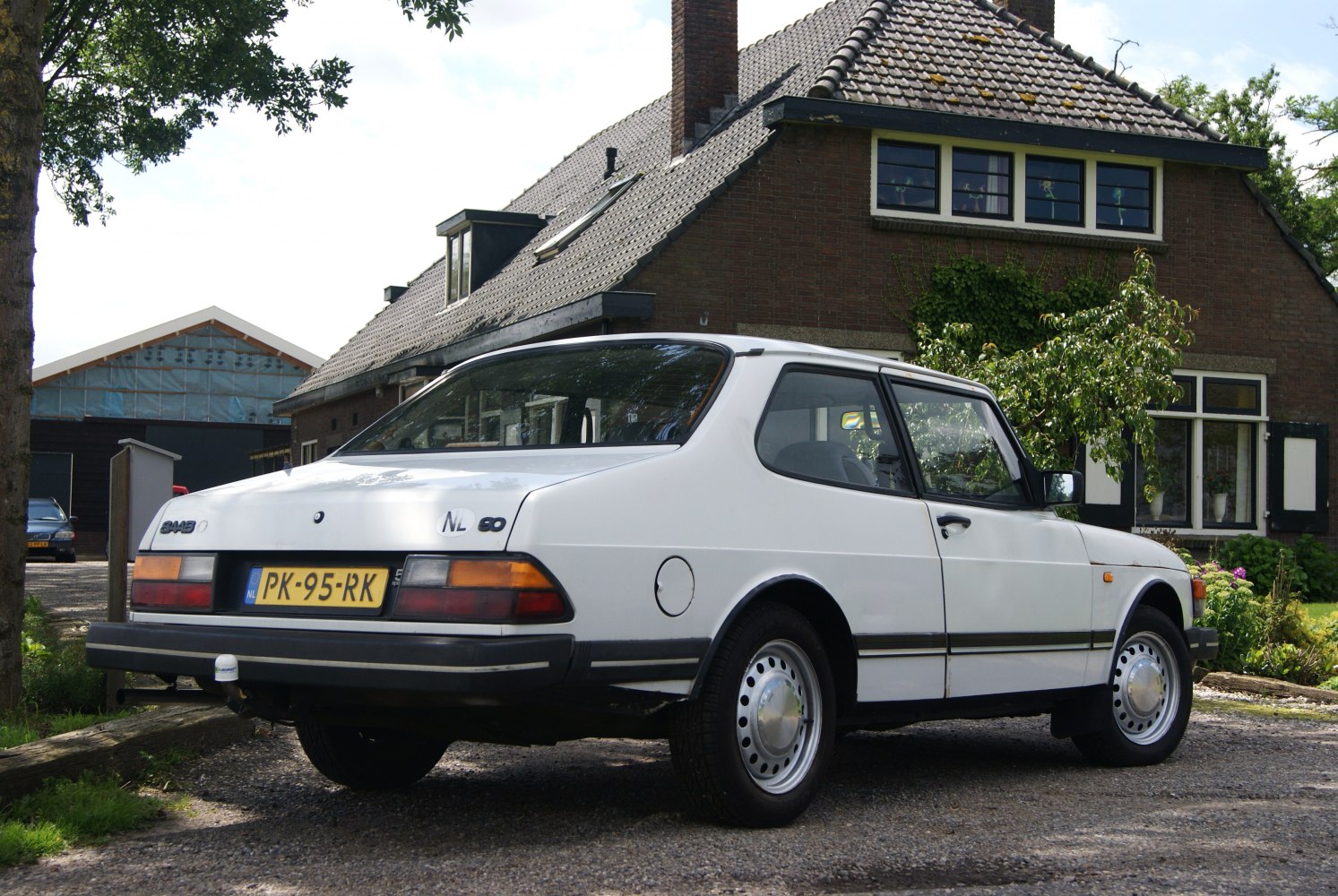 White 1980s hatchback with distinct rear styling and steel wheels