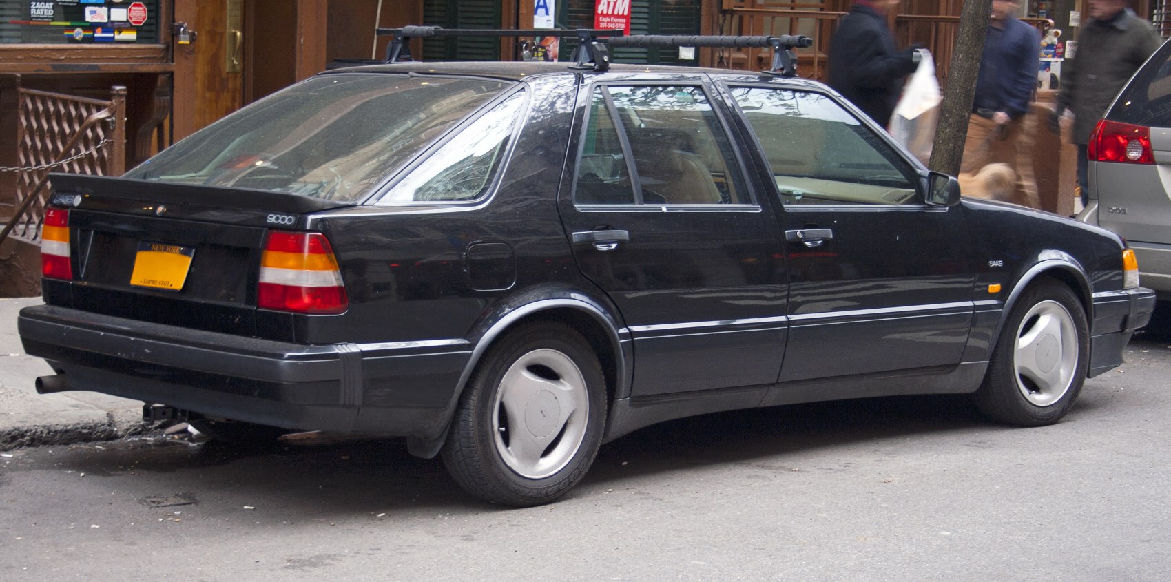 Rear side view of black four-door hatchback with roof rack and classic design
