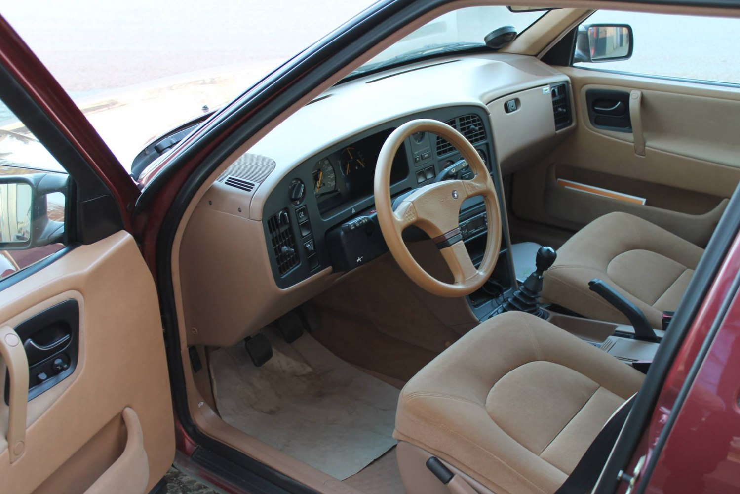 Beige car interior with manual gearshift and classic dashboard