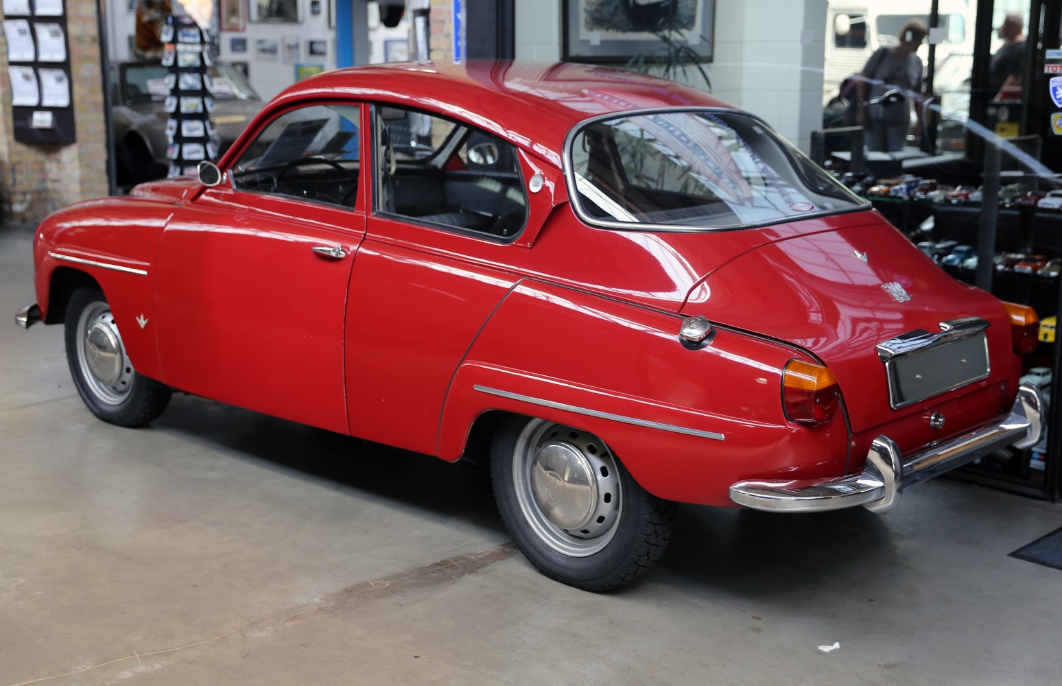 Red vintage two-door coupe with curved rear design and chrome accents