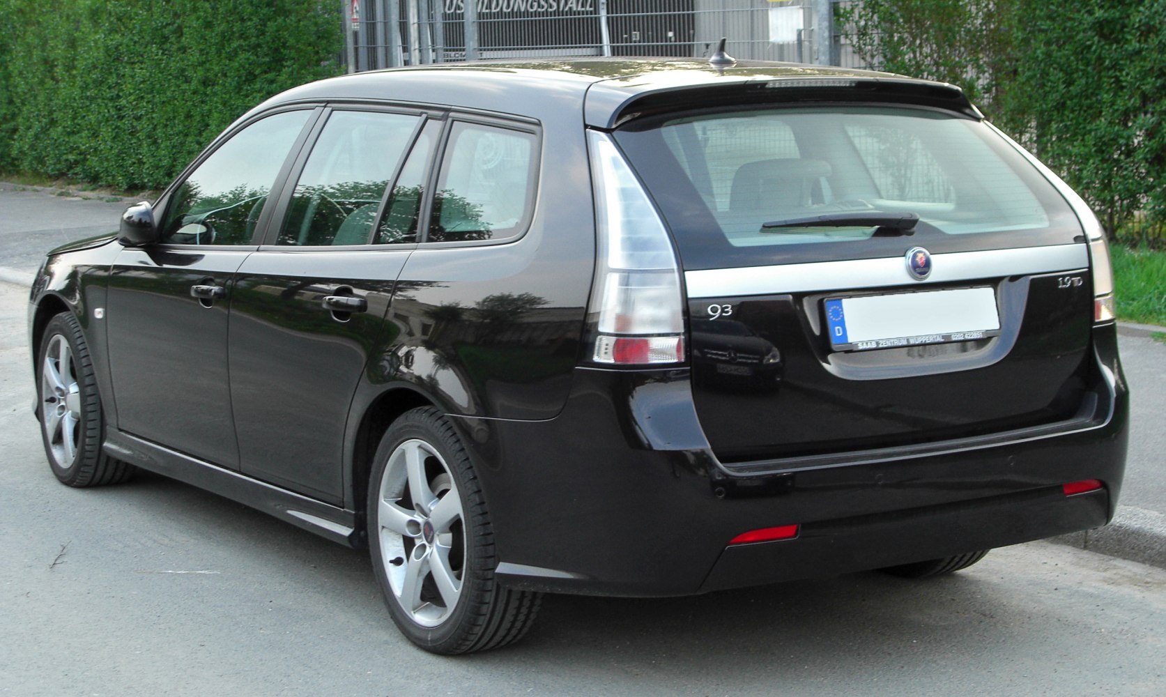 Rear view of a sleek black hatchback with distinctive tail lights.