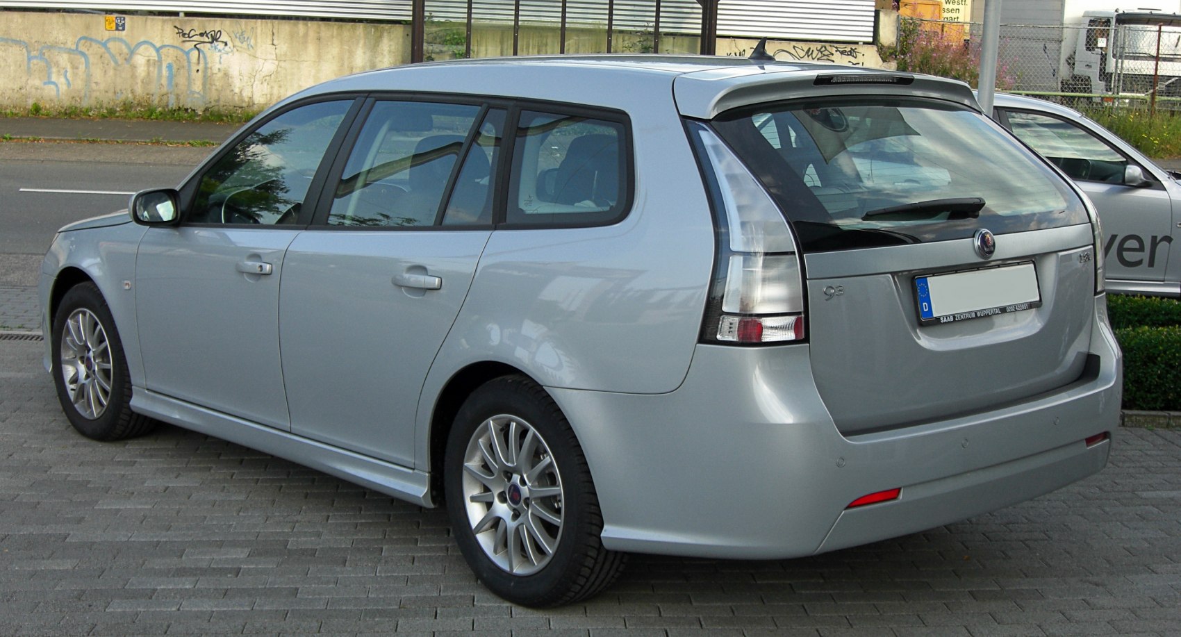 Rear and side view of a silver wagon with distinct taillights and five doors.