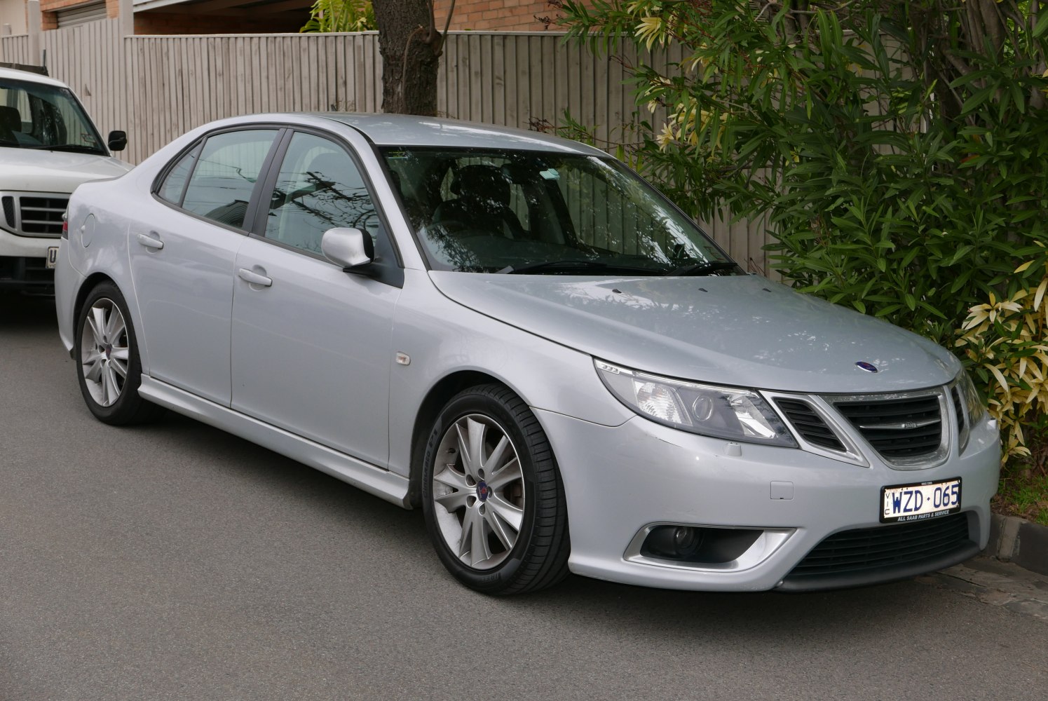Front side view of silver sedan with sharp headlights and grille