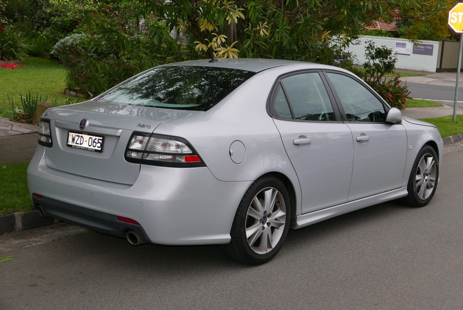 Rear side view of a sedan with dual exhausts and alloy wheels.