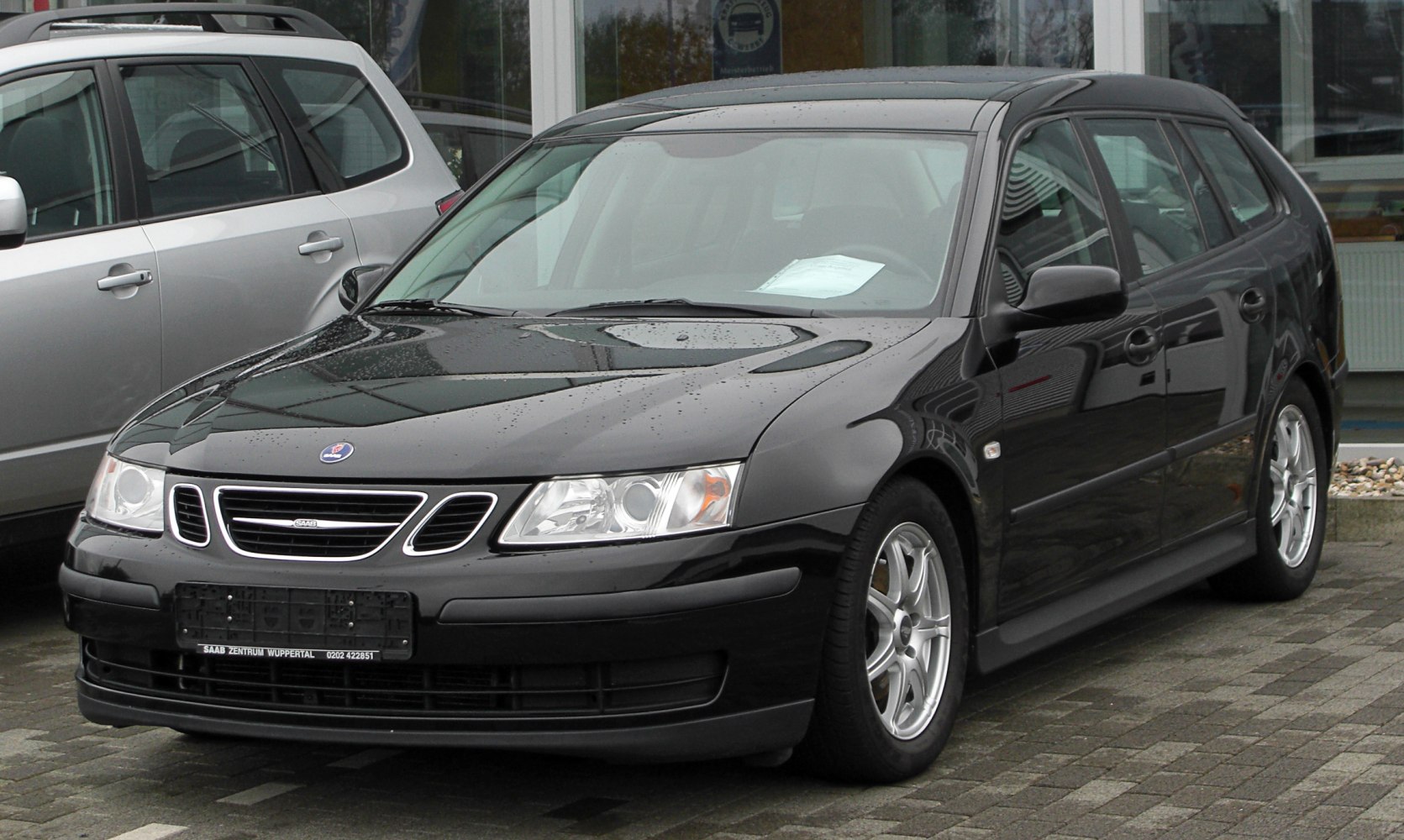 Front and side view of black station wagon with alloy wheels.