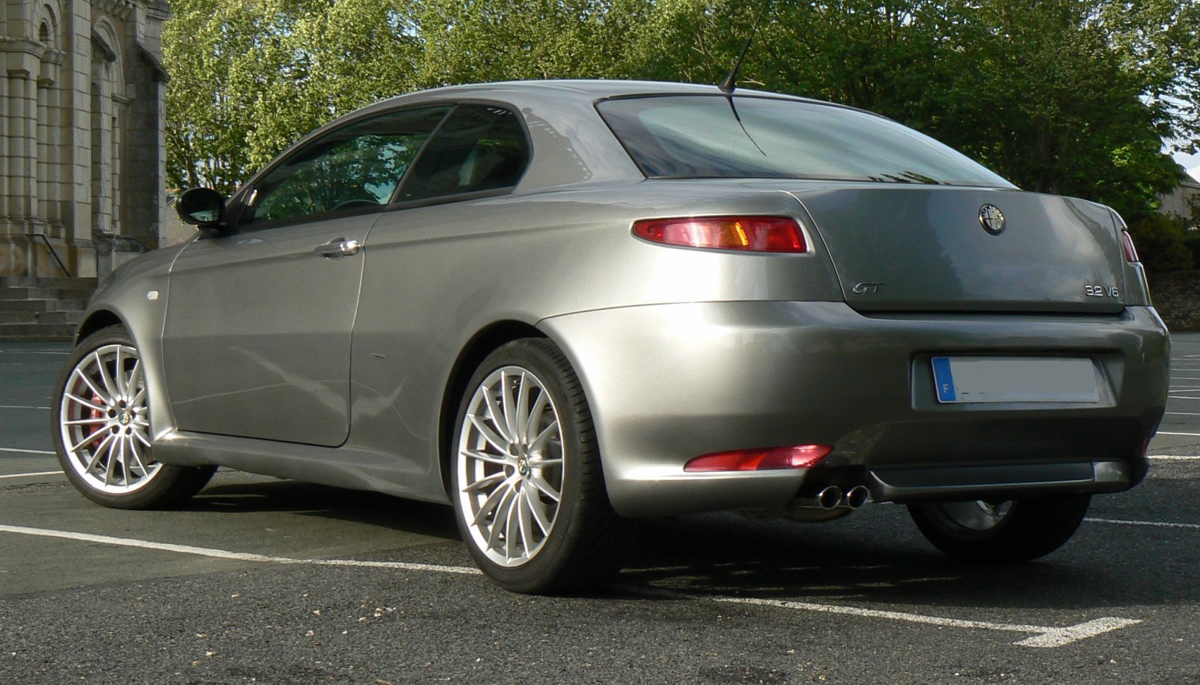 Rear and side view of a coupe with alloy wheels and dual exhaust