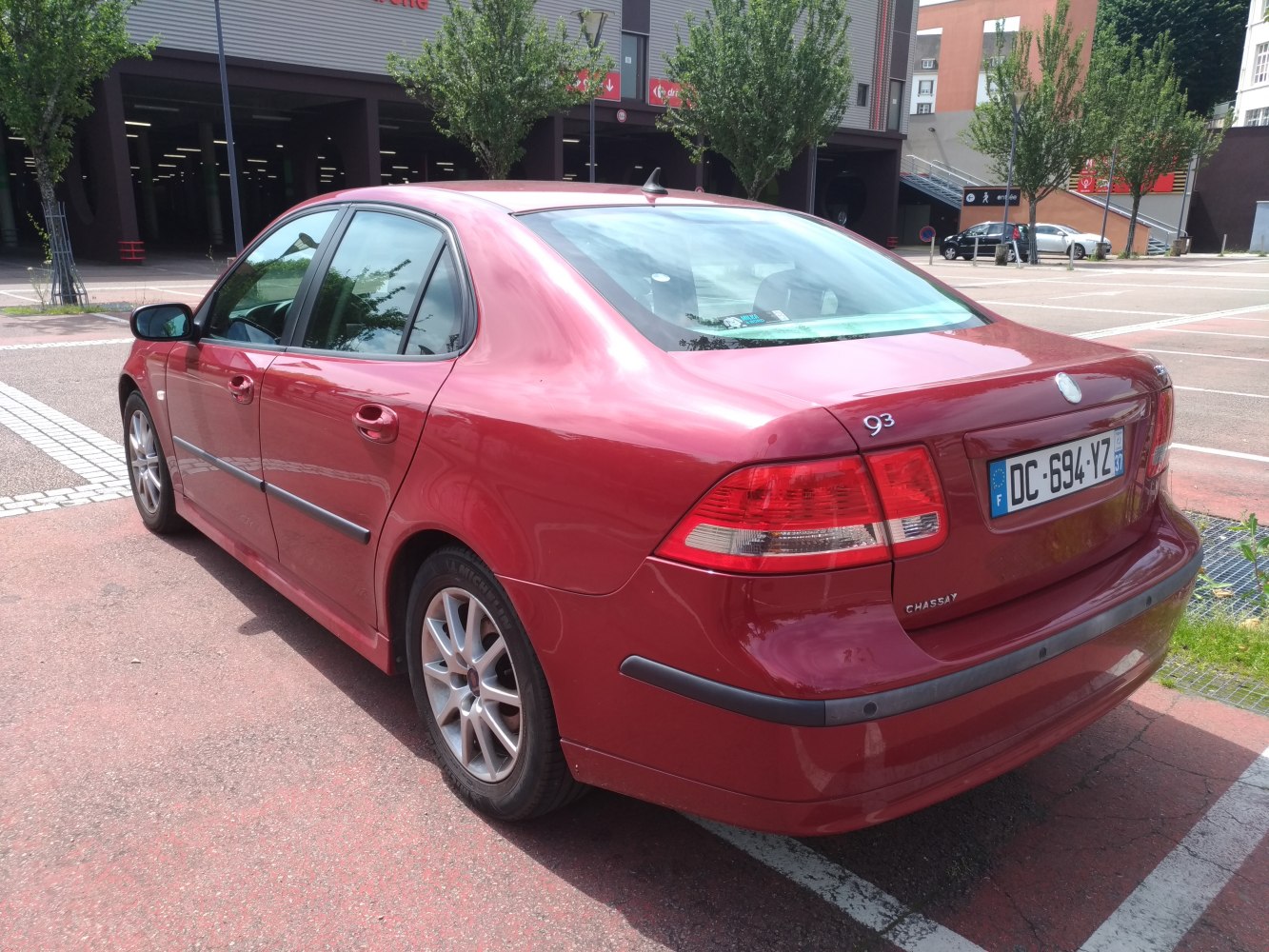 Red four-door sedan rear and side view with taillights and bumper details