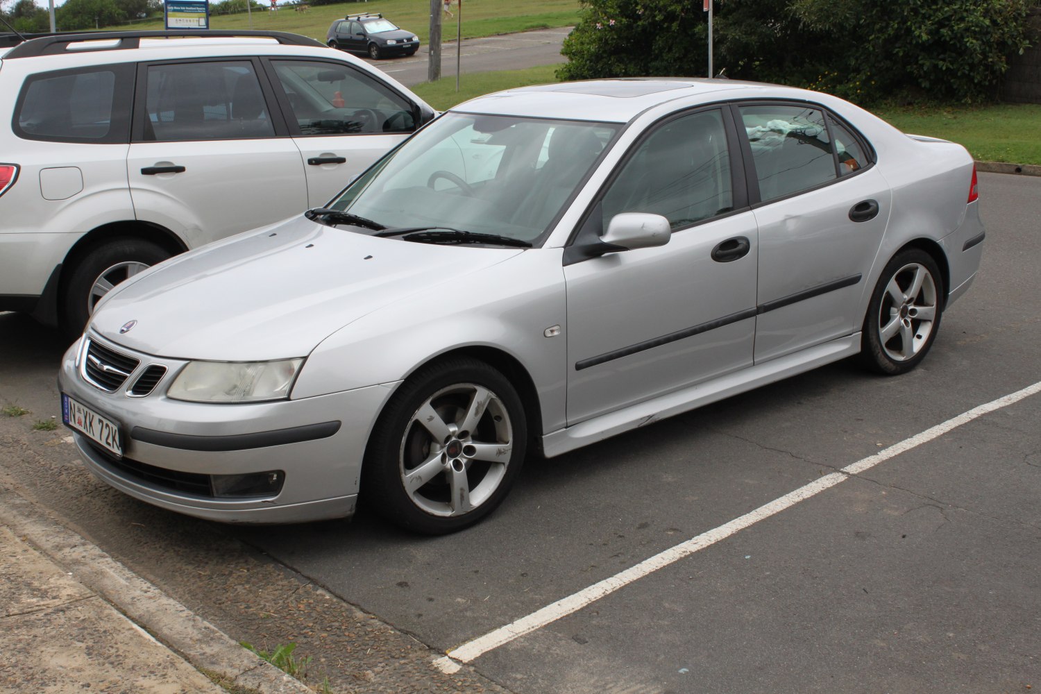 Silver 4-door sedan with alloy wheels parked on street