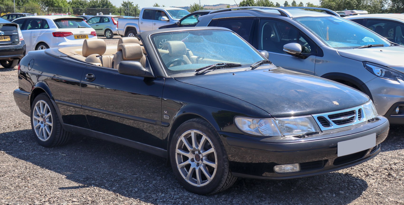 Black convertible with open roof and alloy wheels, front side view