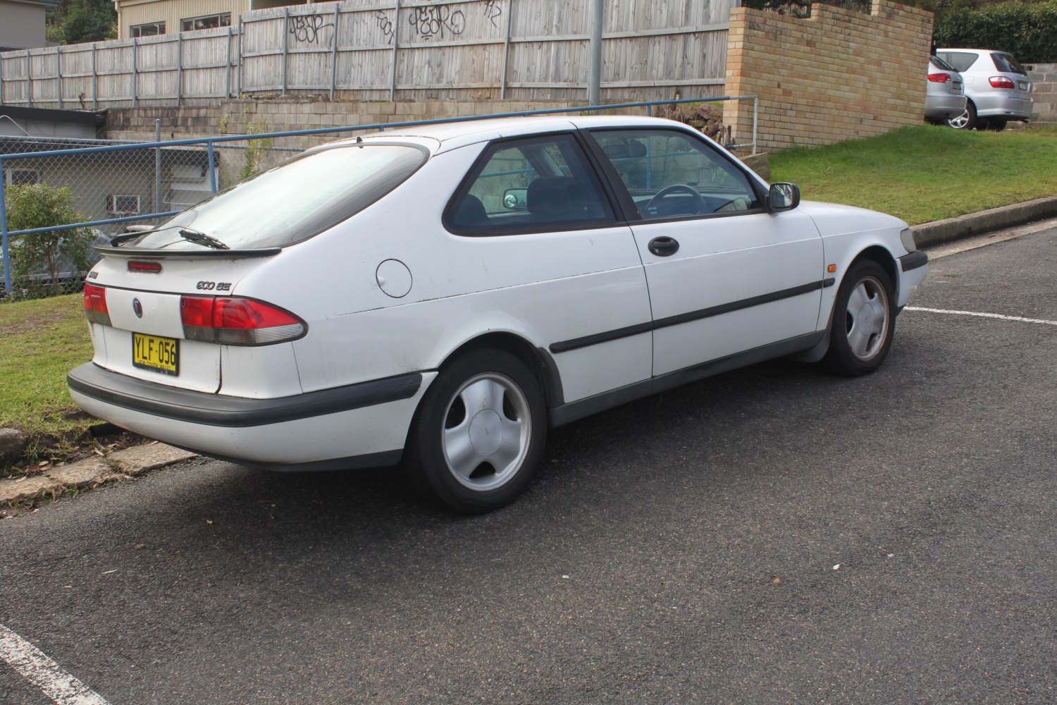 Rear side view of white three-door hatchback with aerodynamic design and alloy wheels