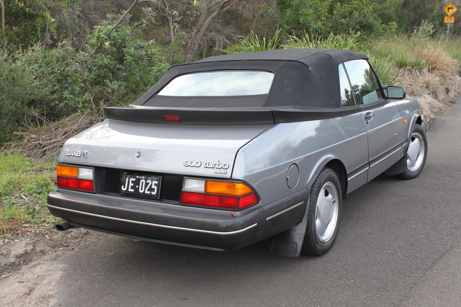 Rear view of a classic convertible with black soft top and distinct turbo badging