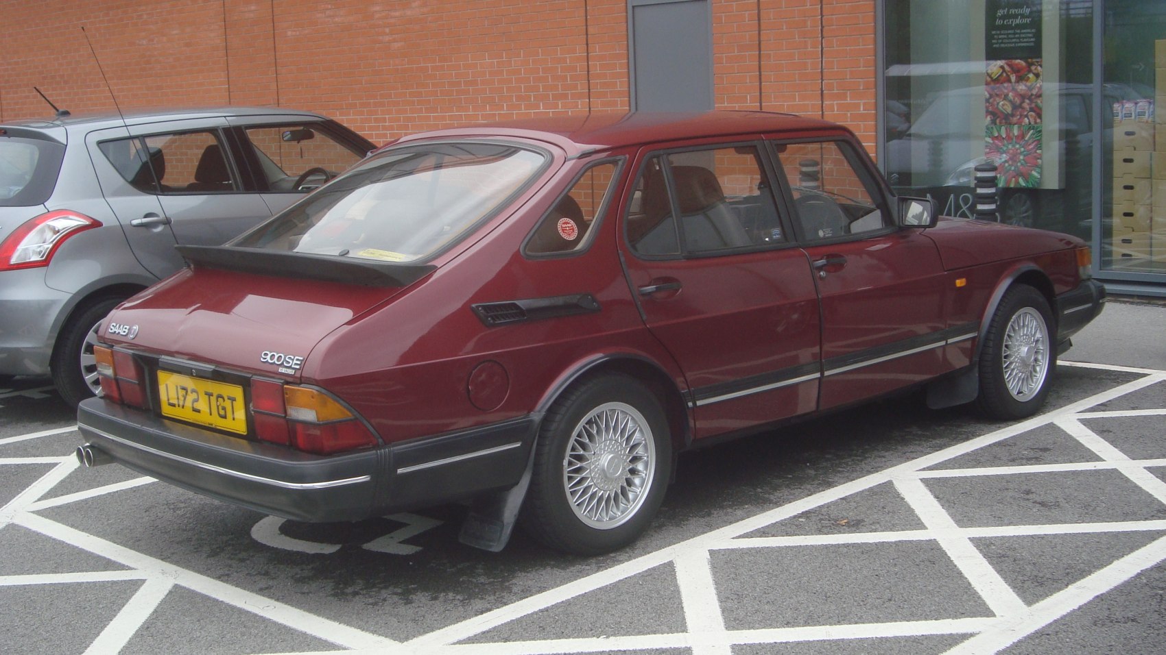 Rear and side view of a classic Saab hatchback with alloy wheels and distinctive sloped tail.