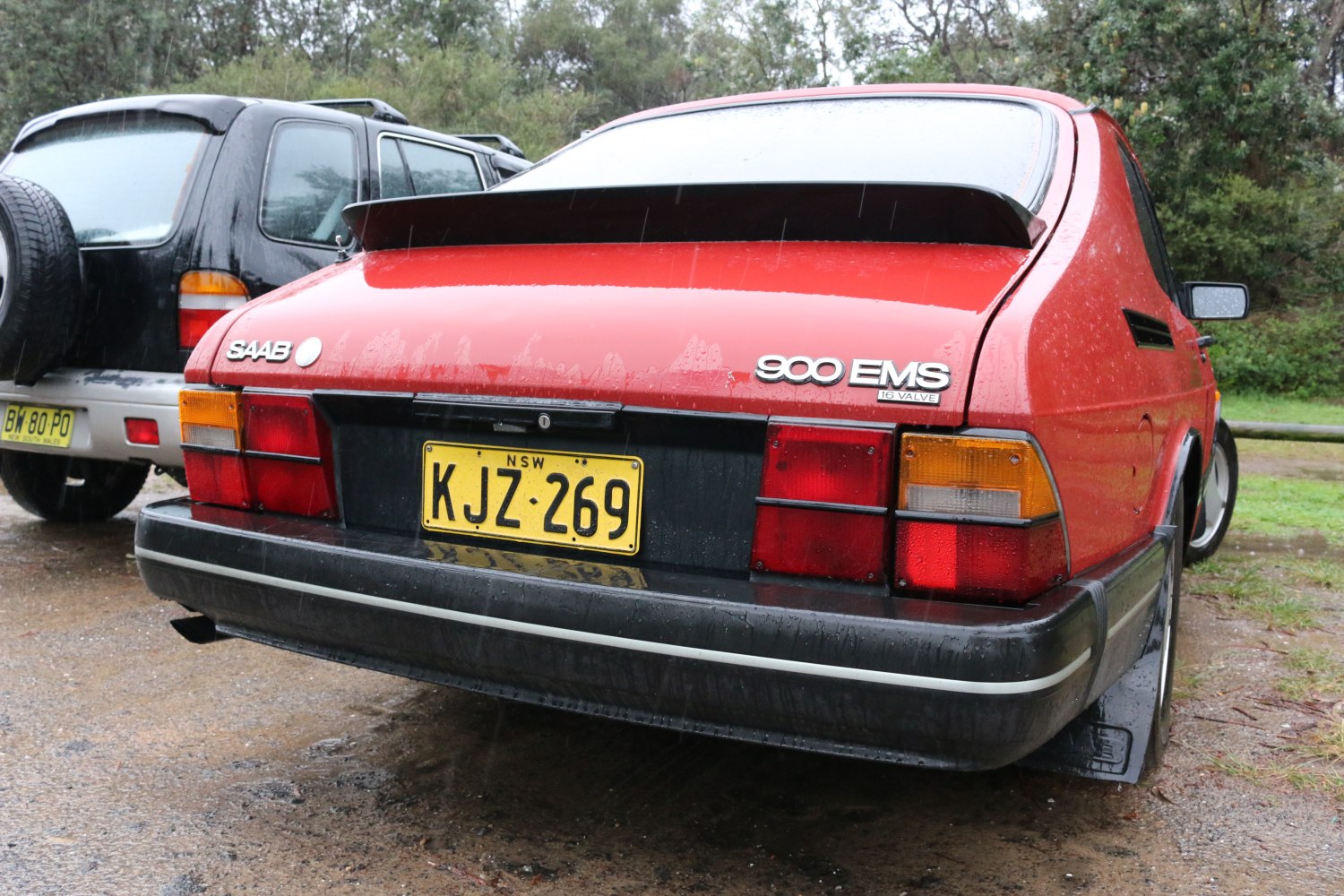 Rear view of a red hatchback with spoiler and distinct taillight design