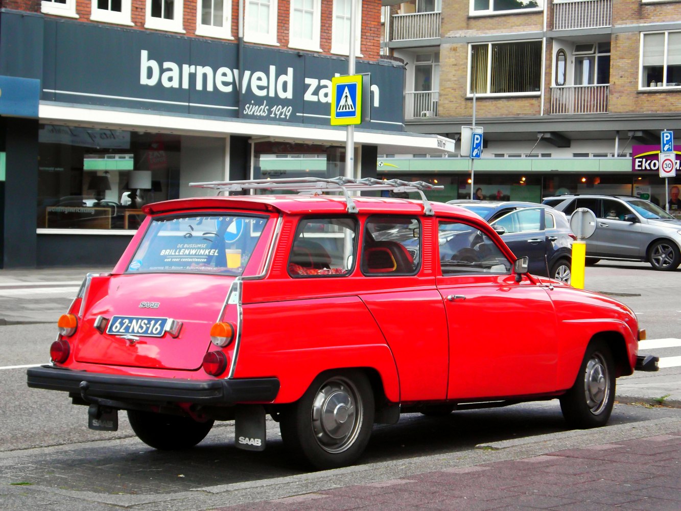 Rear view of a vintage red station wagon with roof rack