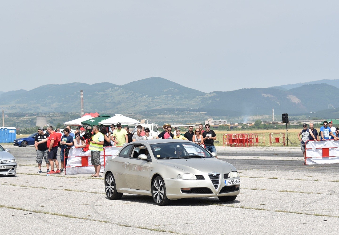 Silver coupe with black multi-spoke alloy wheels on race track