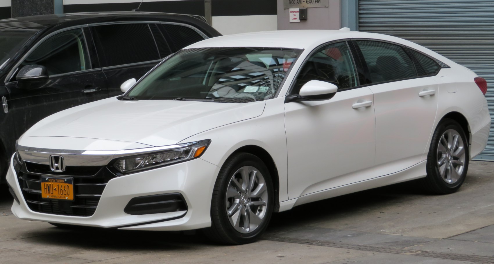 Front side view of a white sedan with sleek design and alloy wheels