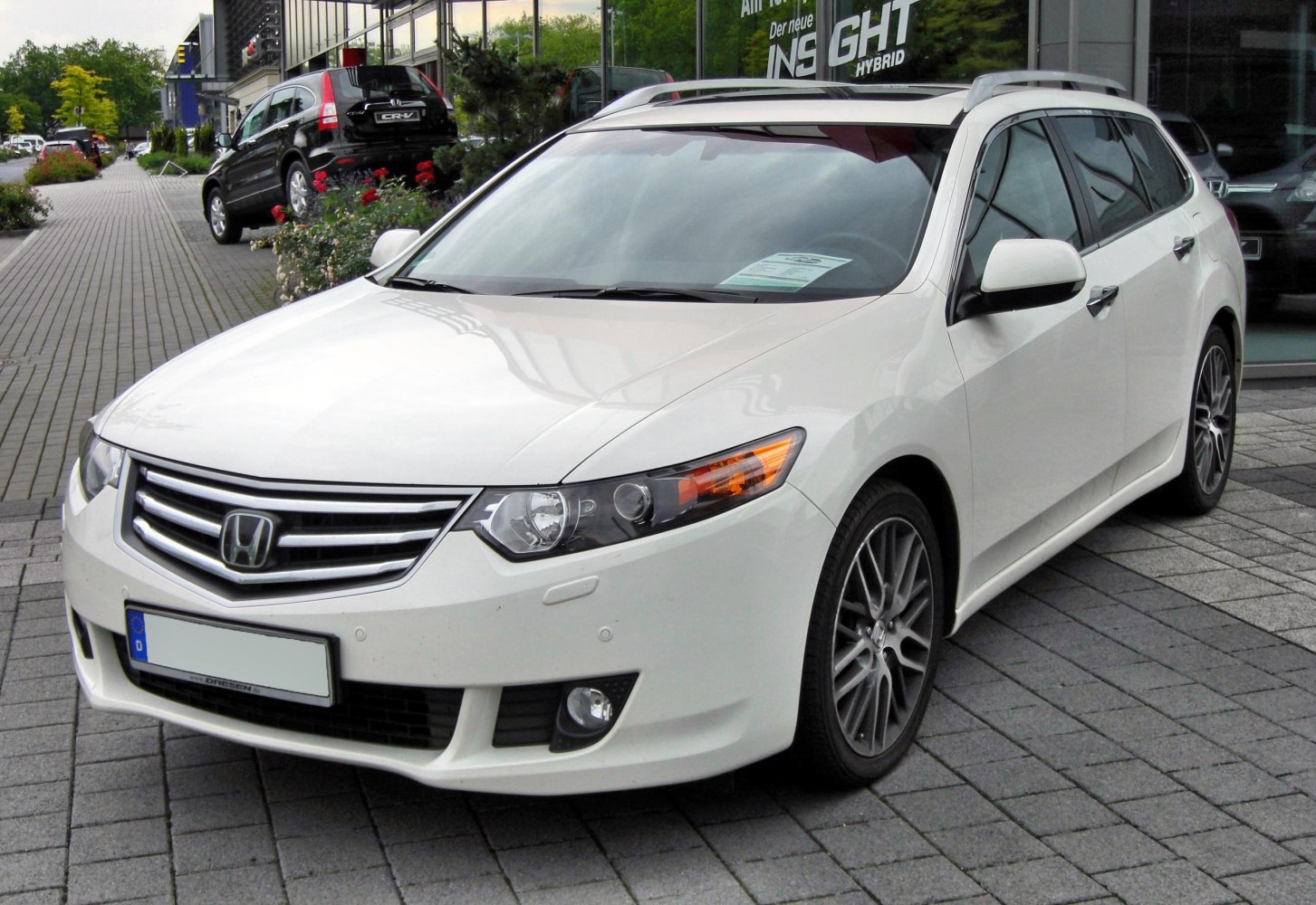 White mid-size wagon with alloy wheels and front fog lights
