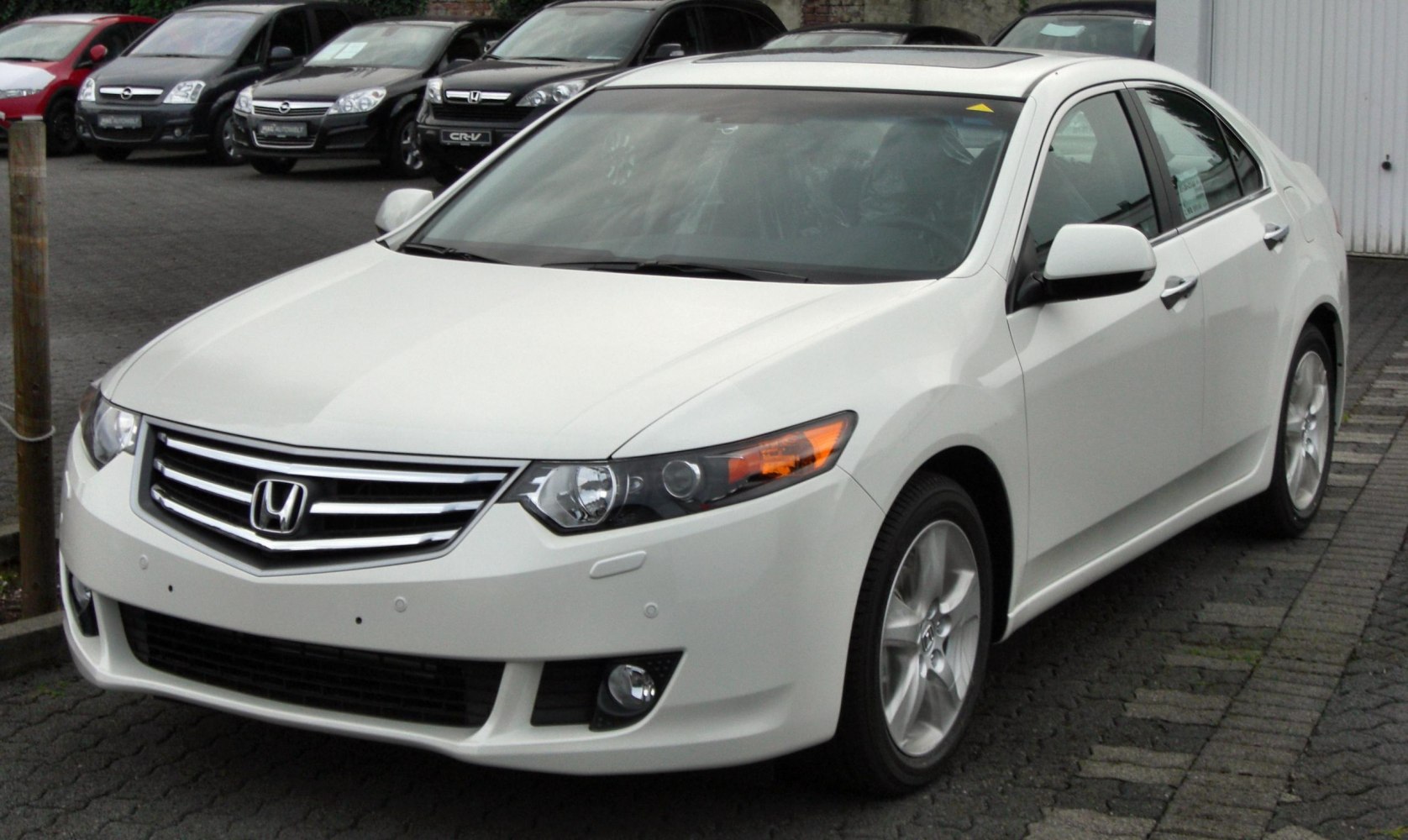 White mid-2000s sedan with angular headlights and chrome grille