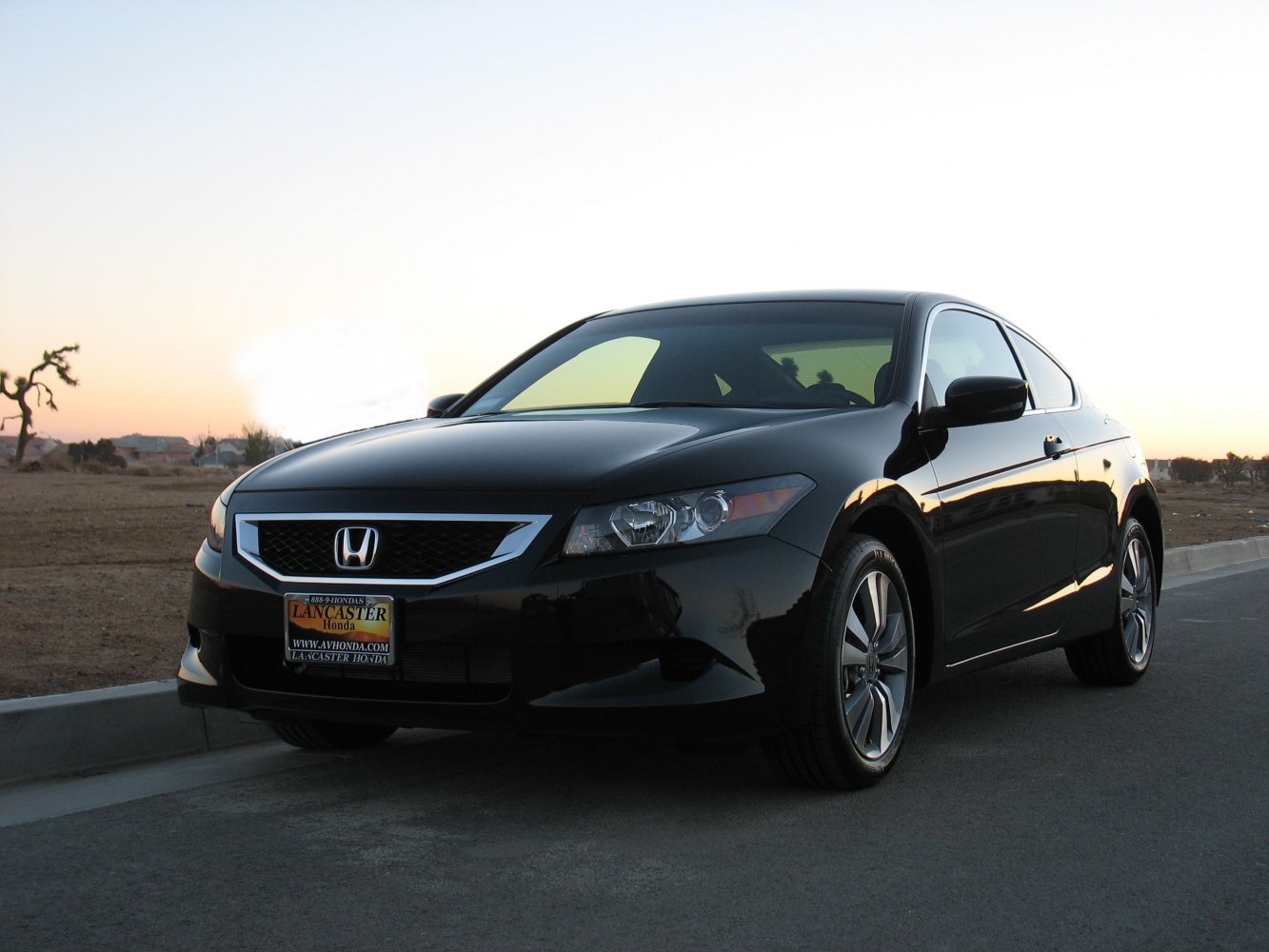 Front three-quarter view of a sleek midsize coupe with aerodynamic design and prominent headlights.
