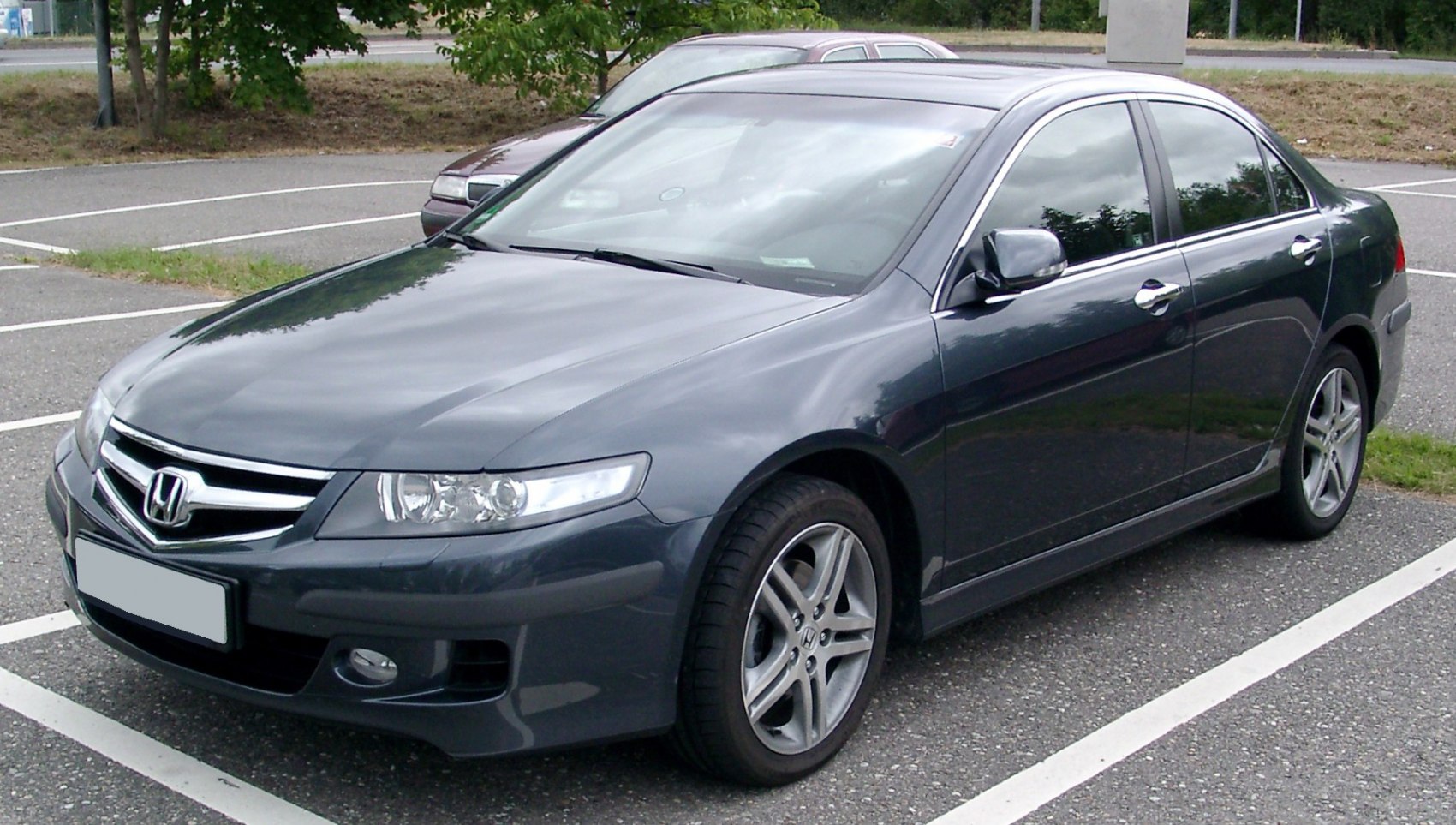 Front and side profile of a mid-2000s four-door sedan with alloy wheels