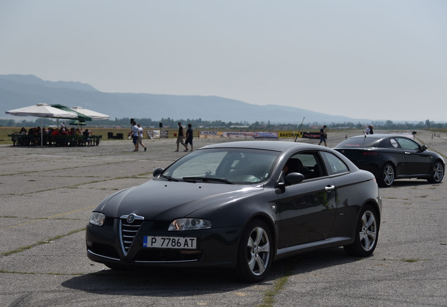 Black sporty coupe shown from side-front angle on open pavement
