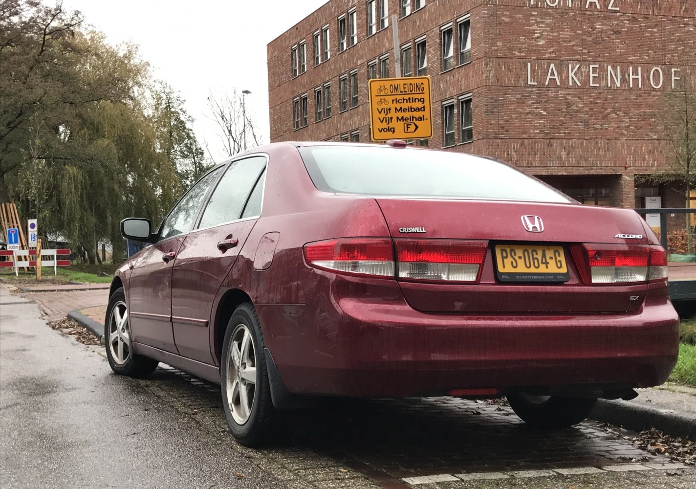 Rear view of sedan with distinct taillights and red paint