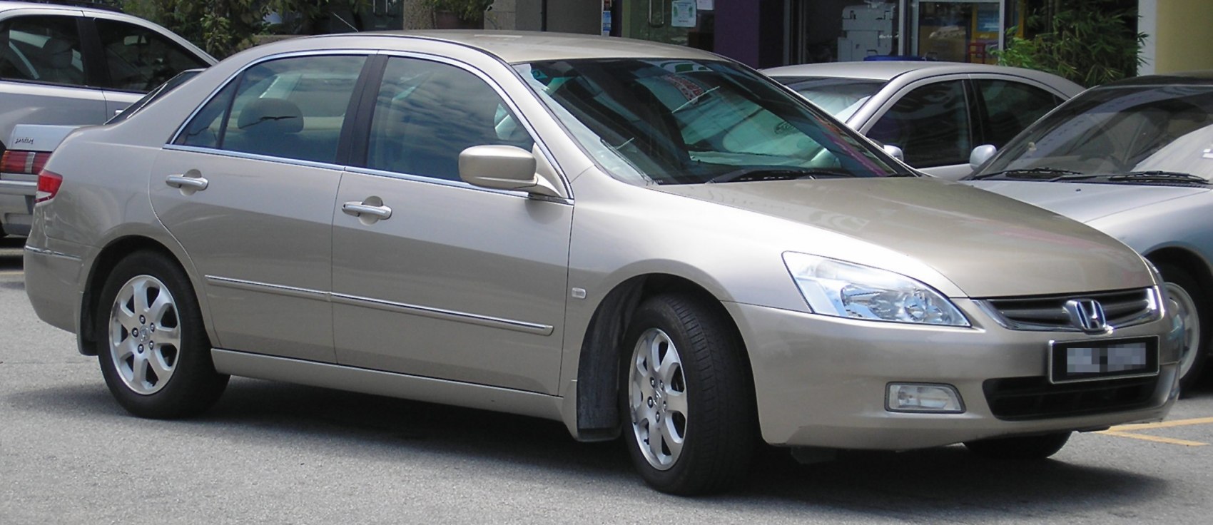 Side and front-right view of a beige four-door sedan with alloy wheels