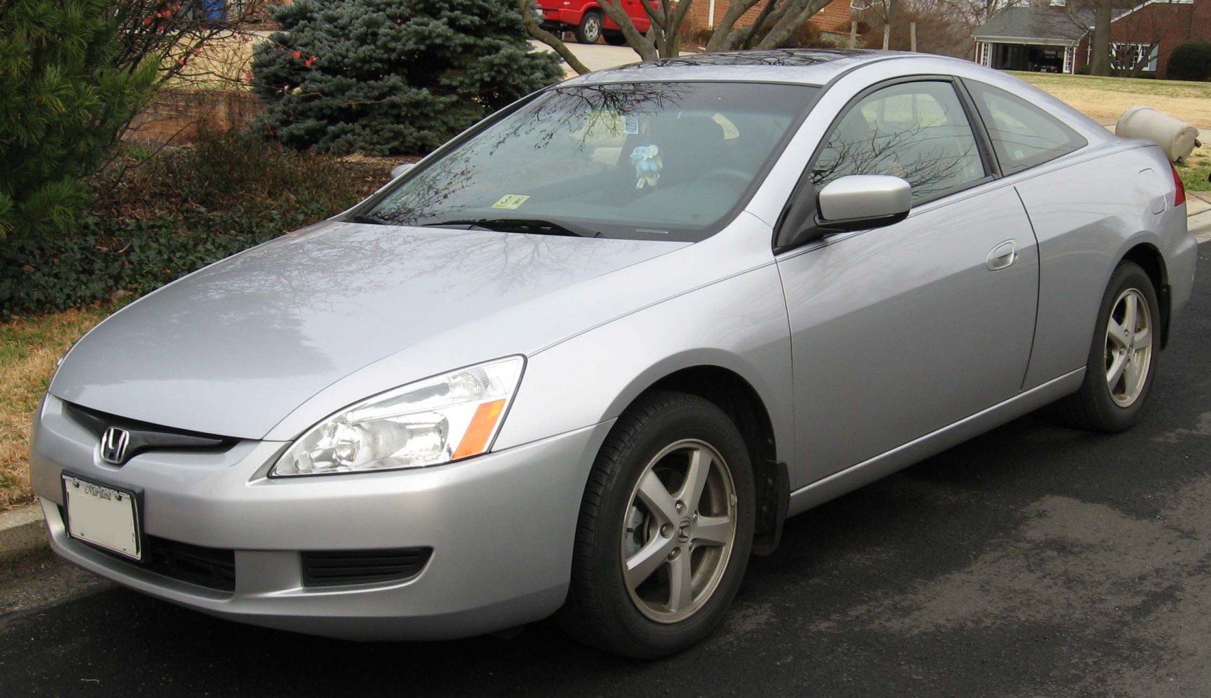 Silver compact coupe with sleek headlights and five-spoke alloy wheels