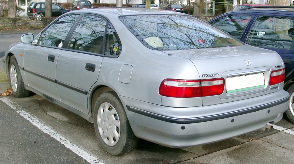 Rear and side view of silver sedan with classic 90s styling