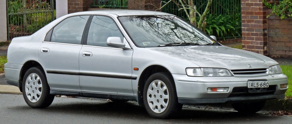 Silver 1990s sedan side profile with classic wheels