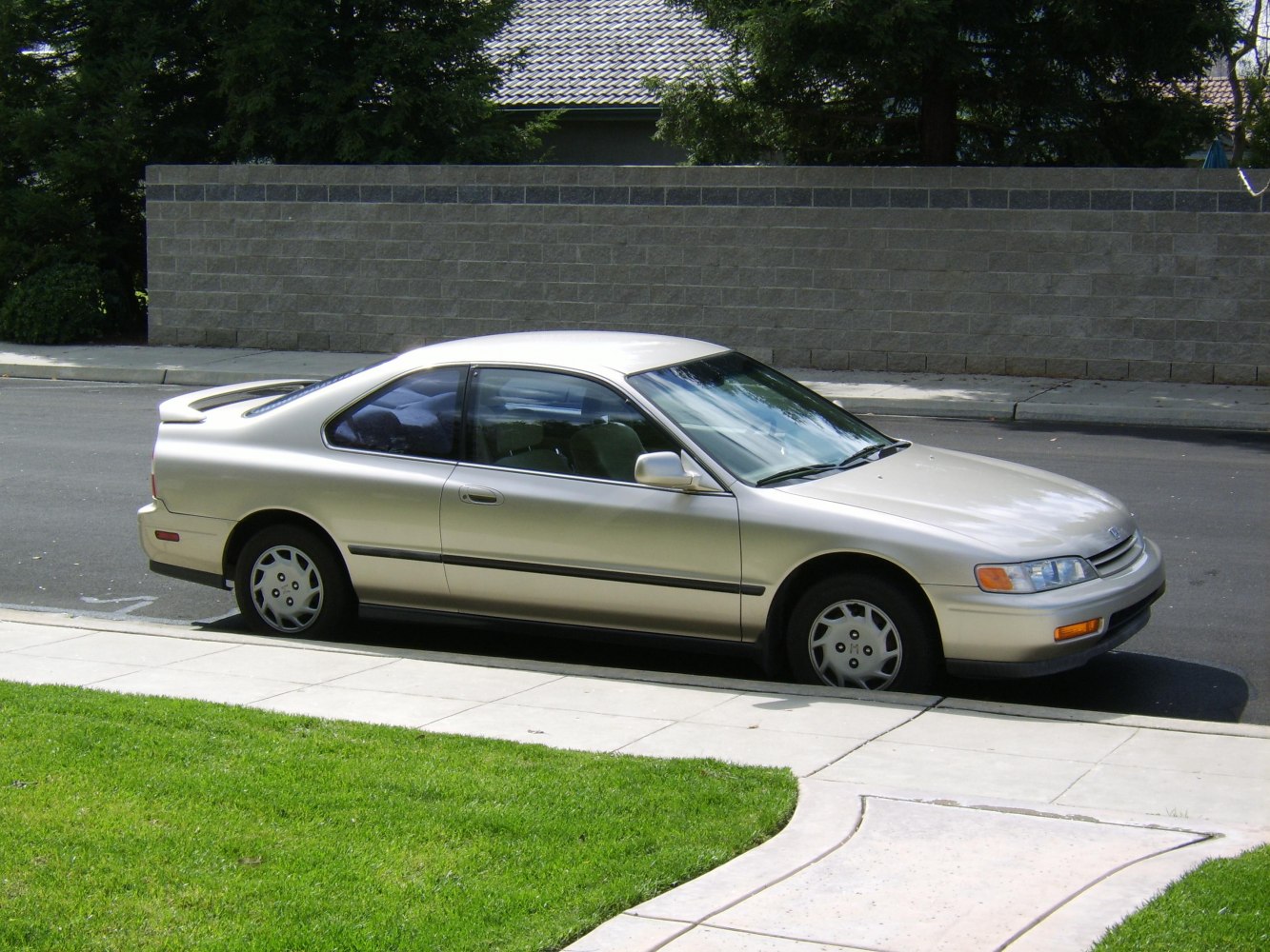 Side profile of a 90s two-door coupe with a rear spoiler