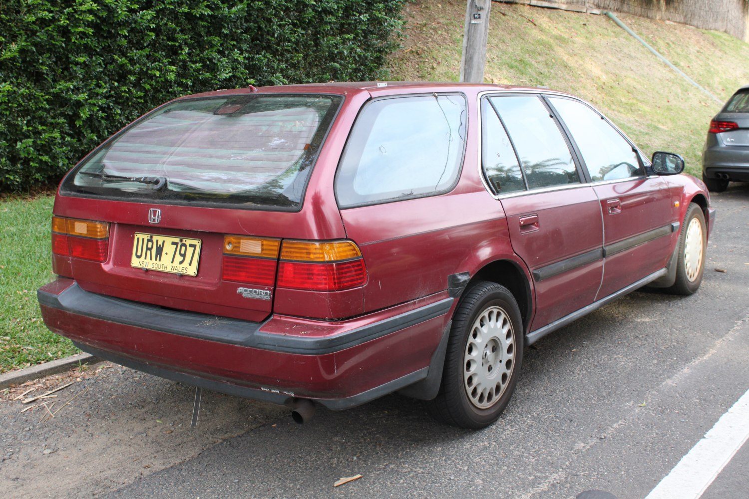 Rear and side view of a red station wagon with hatchback design and classic tail lights