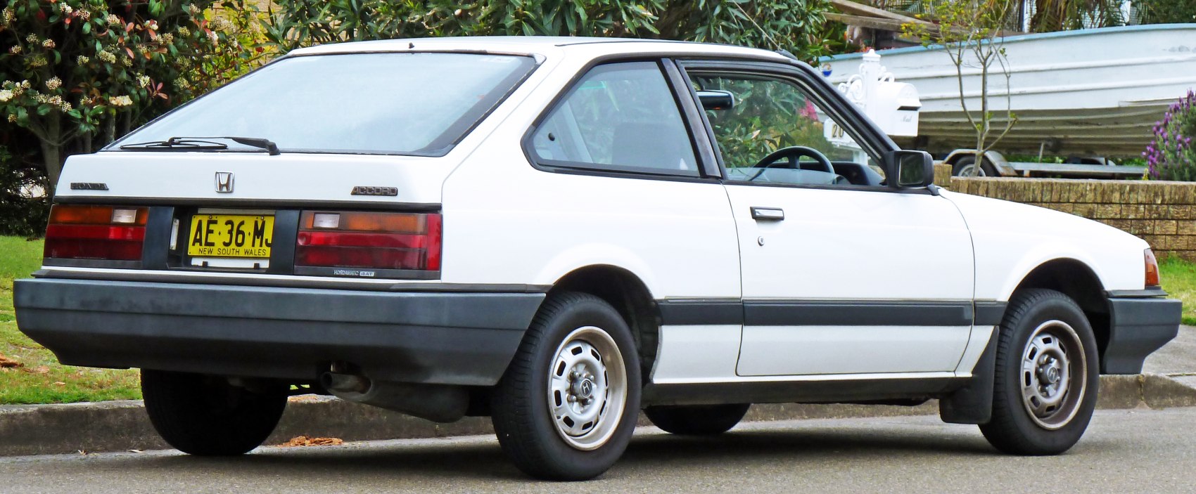 Angular rear side profile with large plastic bumper and rear hatch wiper.