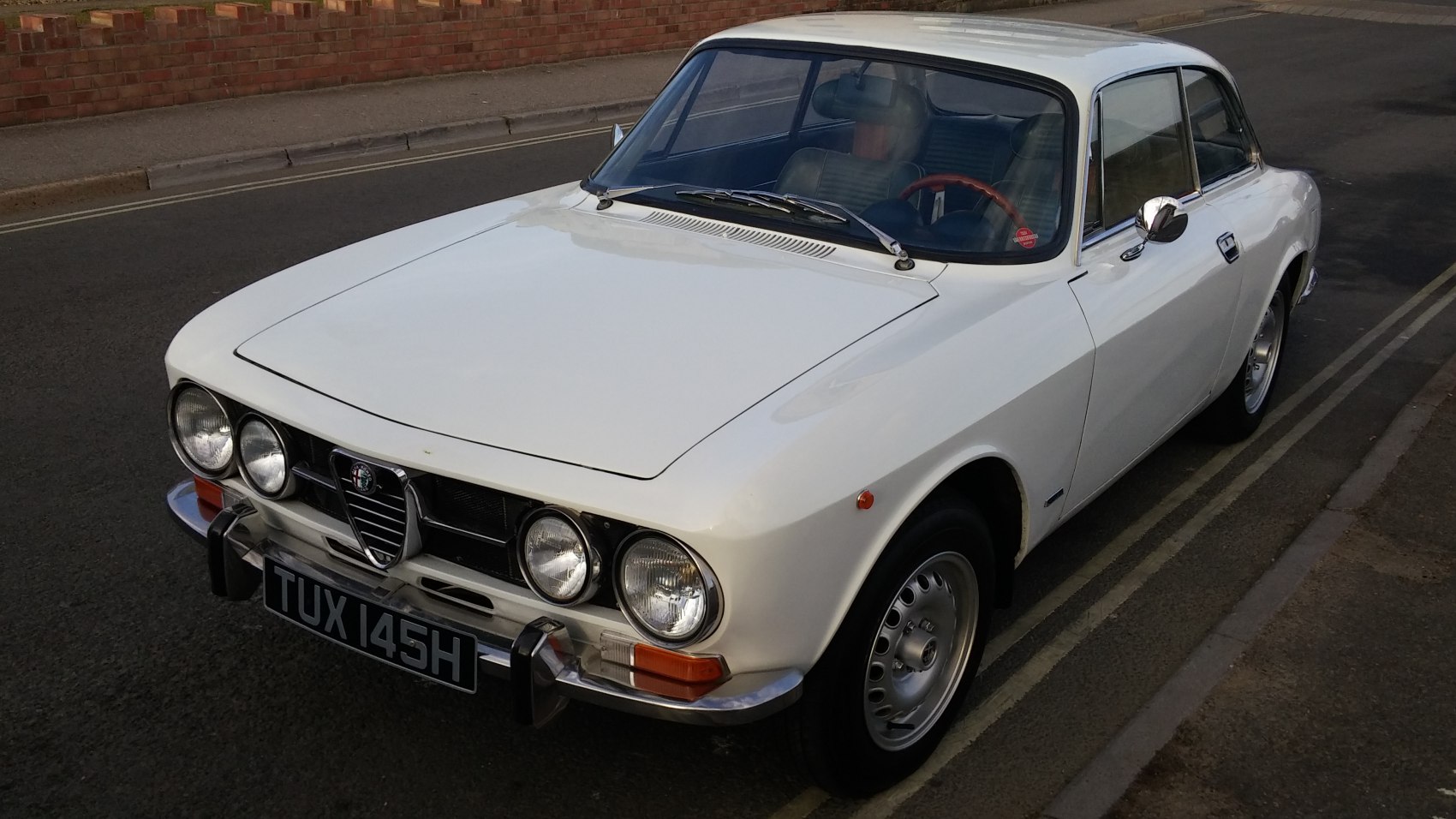 White classic coupe with quad round headlights and chrome bumpers