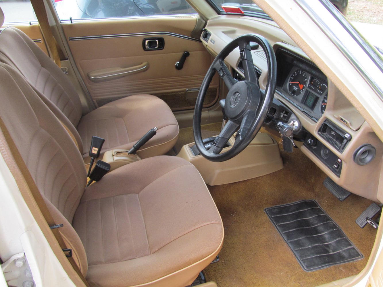 Brown upholstery interior with manual controls and vintage dashboard