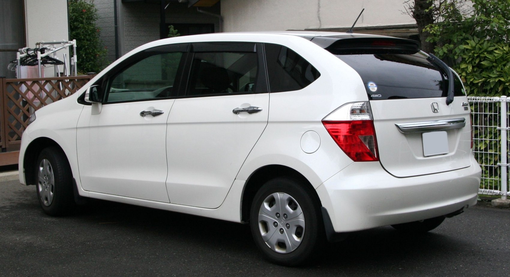 Rear and side profile of a compact MPV with hatchback design and rear spoiler