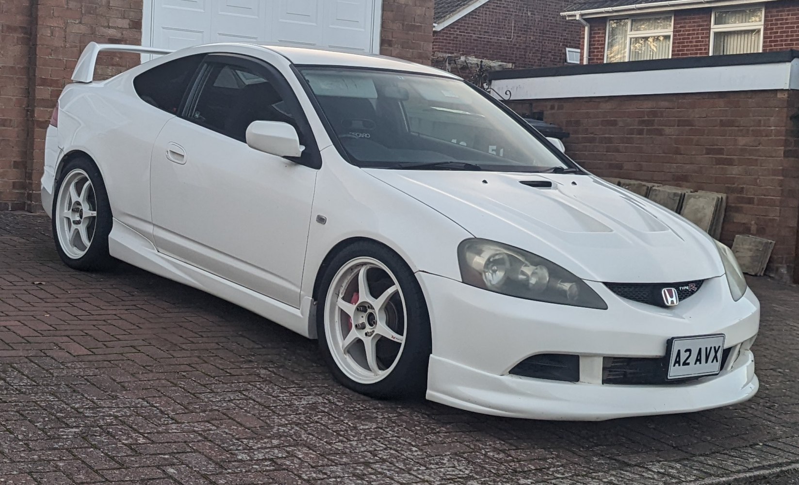 White coupe with sporty wheels and large rear spoiler