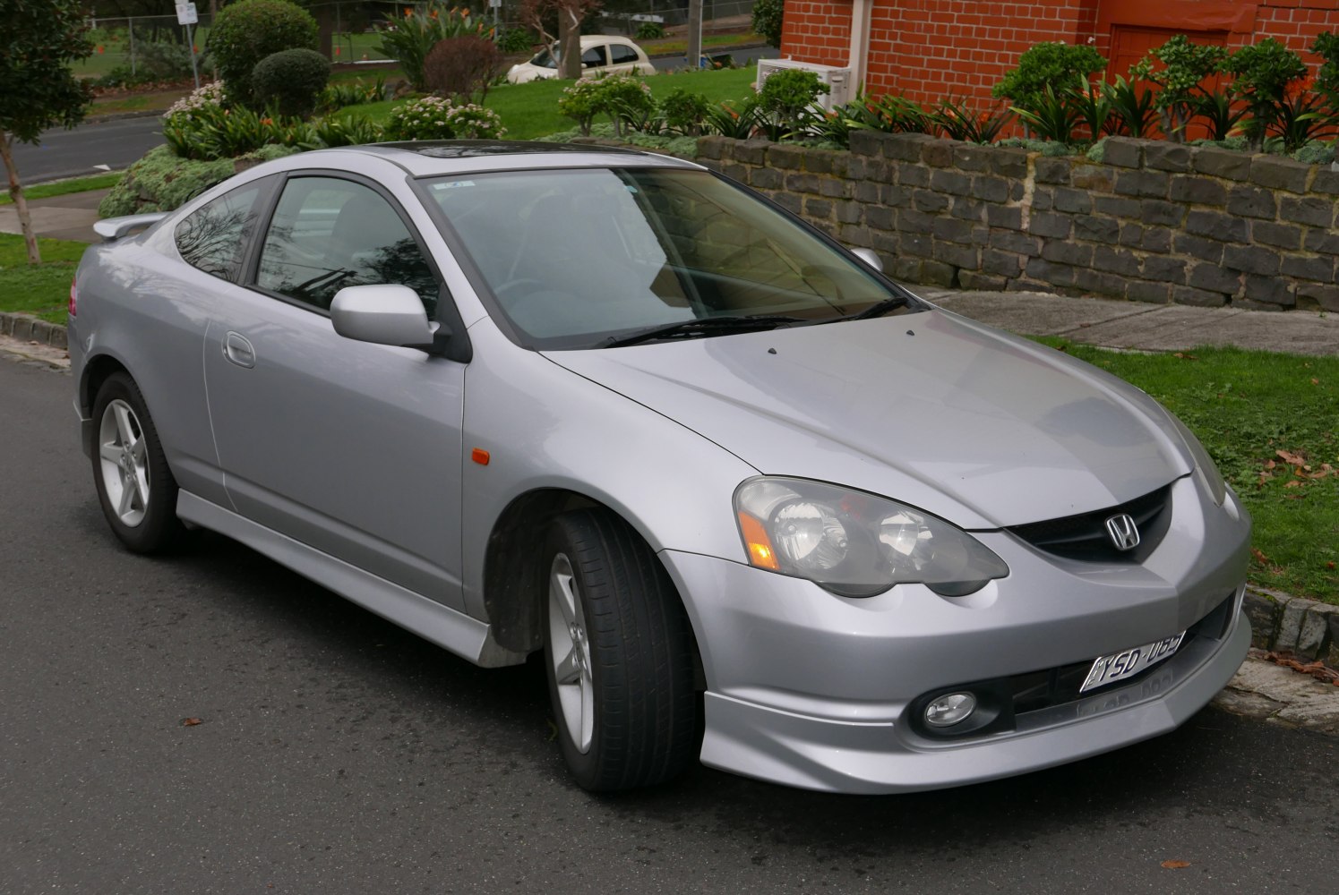 Silver two-door coupe with sporty front end and rear spoiler