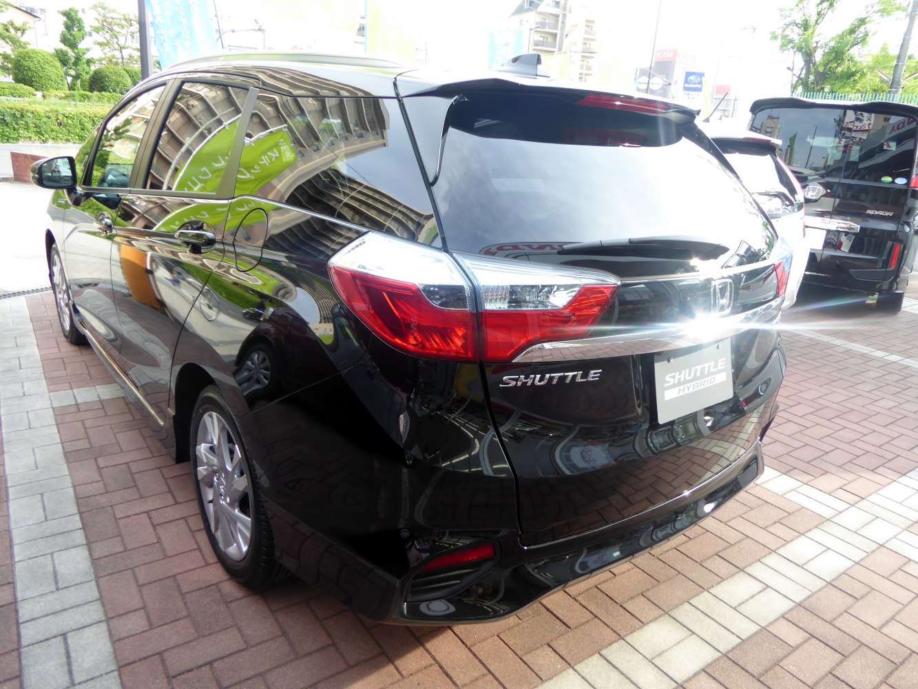 Rear view of car with distinctive tail lights and hybrid badge