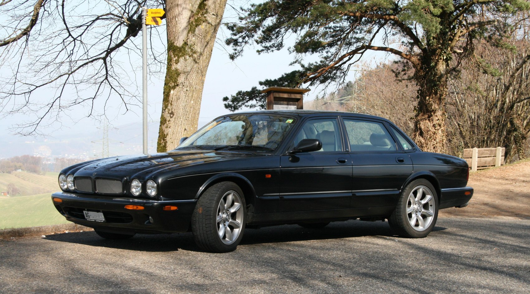 Black sedan with quad round headlights and alloy wheels